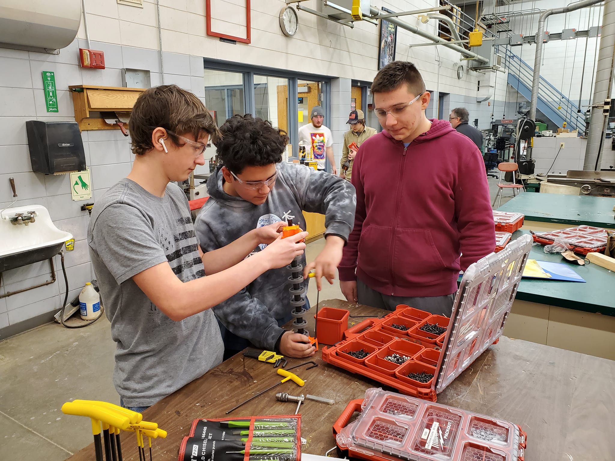 Freshmen Andrew O'Toole, Brolin Cliver, and Luc Pomazak work on a prototype of a robot mechanism